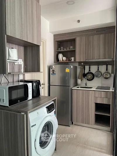 Modern compact kitchen with washing machine and sleek wooden cabinets