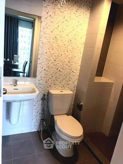 Modern bathroom with sleek design and tiled shower area in a contemporary apartment.