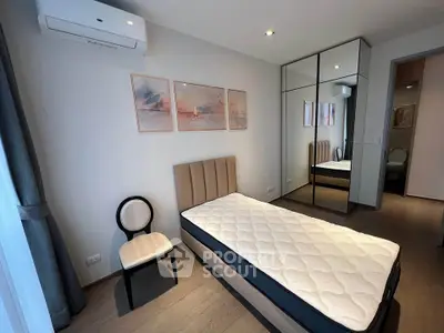 Modern bedroom with single bed, mirrored wardrobe, and stylish decor in a bright apartment.