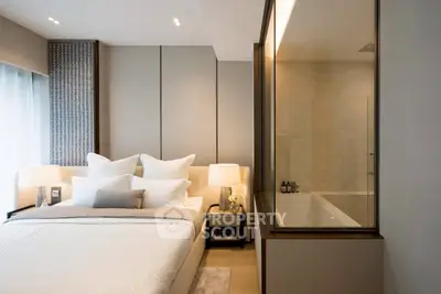 Luxurious bedroom with elegant decor and ensuite bathroom in modern apartment.