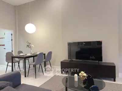 Modern living room with sleek furniture and dining area, featuring a stylish TV setup and elegant decor.