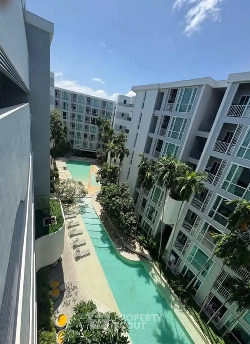 Luxurious apartment complex with stunning pool and lush greenery