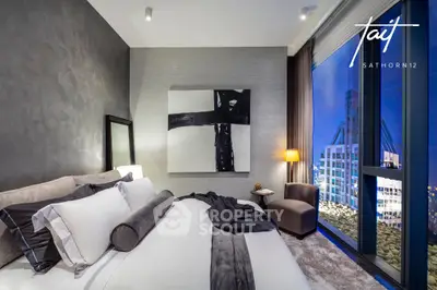 Luxurious bedroom with plush bedding, modern decor, and stunning city views through floor-to-ceiling windows, offering an urban oasis in a prime location.