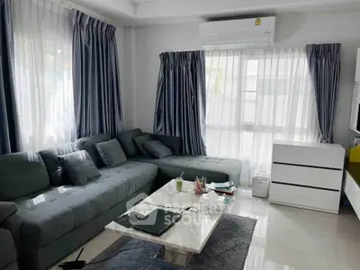 Spacious living room with modern gray sectional sofa and marble coffee table