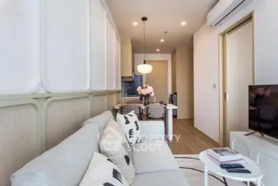 Modern living room with cozy sofa, stylish decor, and open kitchen layout in a contemporary apartment.
