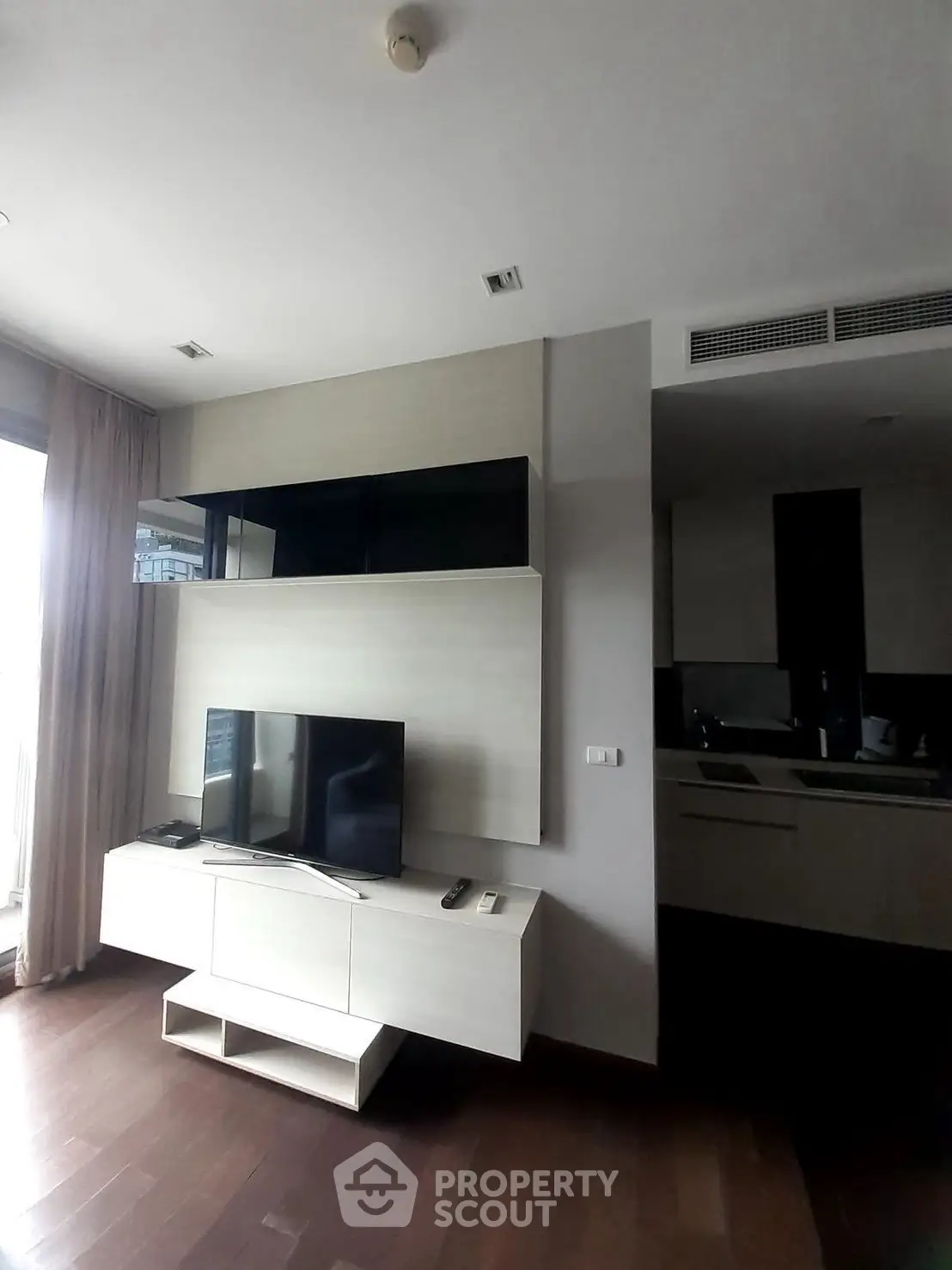Modern living room with sleek TV stand and open kitchen layout