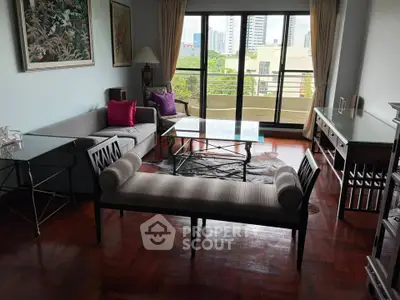 Spacious living room with elegant furniture and city view balcony, perfect for urban living.