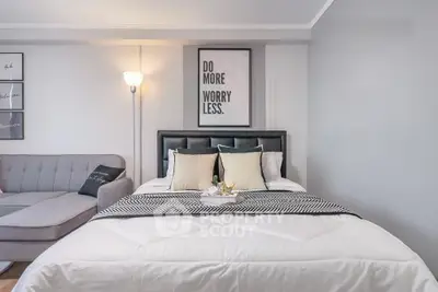 Modern bedroom with stylish decor and cozy seating area, perfect for relaxation.