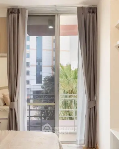 Modern bedroom with balcony view and elegant curtains in urban apartment