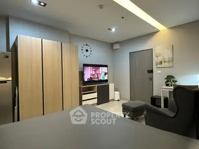 Modern living room with stylish furniture and wall-mounted TV in a cozy apartment.