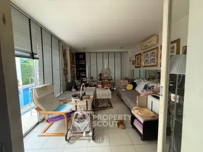 Spacious living room with pool view, modern furniture, and ample natural light.