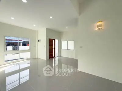 Spacious modern living room with large windows and elegant lighting