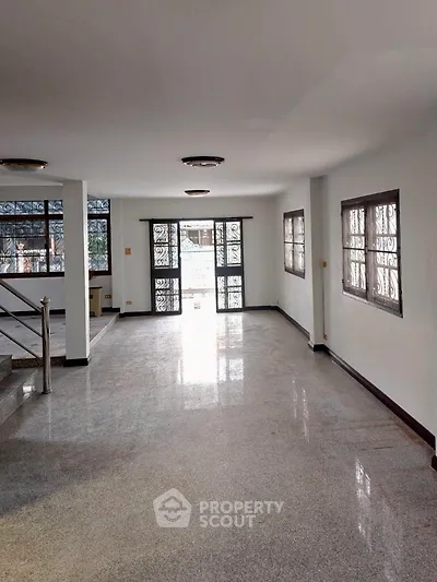 Spacious empty room with large windows and polished floors, ideal for customization.