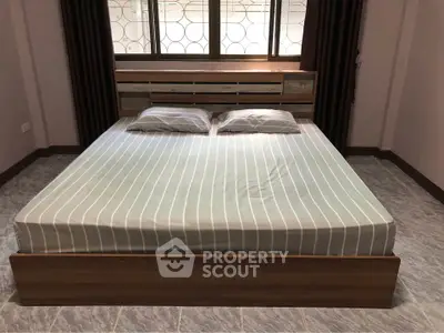 Spacious bedroom with modern bed and large window for natural light.