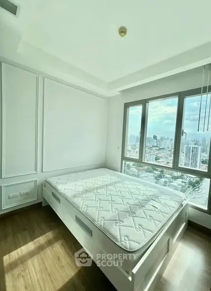 Bright bedroom with large window offering stunning city views and modern minimalist design.