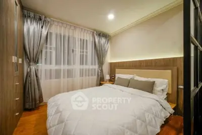 Cozy bedroom with modern decor and elegant curtains, perfect for relaxation.