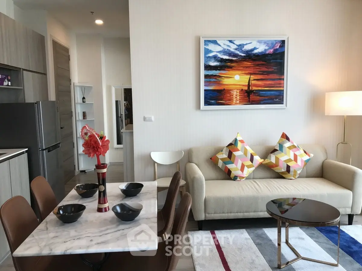 Modern living room with stylish decor, open kitchen, and vibrant artwork, perfect for contemporary urban living.