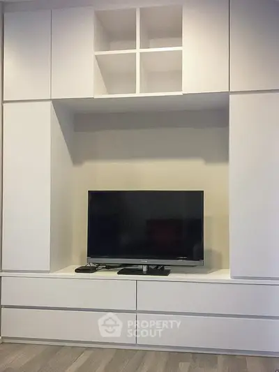 Modern living room with sleek built-in TV cabinet and ample storage space.
