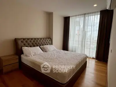 Spacious bedroom with large window and elegant decor in modern apartment