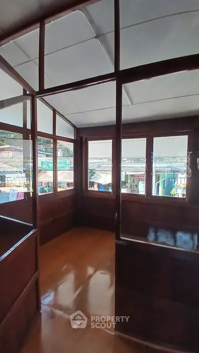 Charming wooden interior with large windows offering scenic views of the surrounding area.