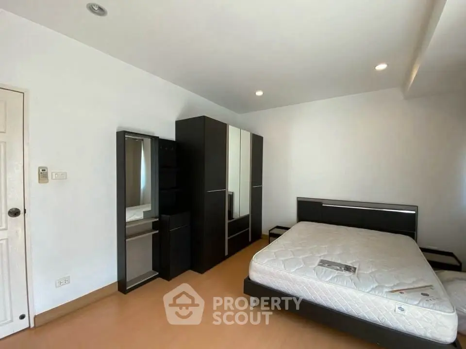 Spacious bedroom with modern furniture and ample natural light