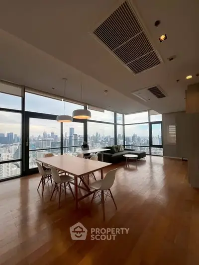Spacious modern living room with panoramic city views and elegant dining area.