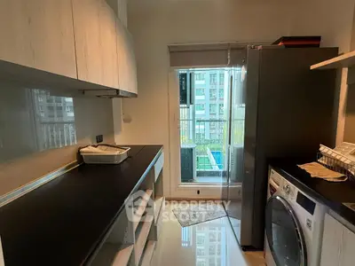Modern kitchen with sleek appliances and balcony view in urban apartment