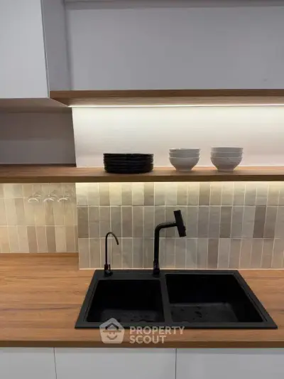 Modern kitchen with sleek black sink and stylish wooden countertop