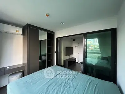 Modern bedroom with sleek design and large window offering natural light and city view.