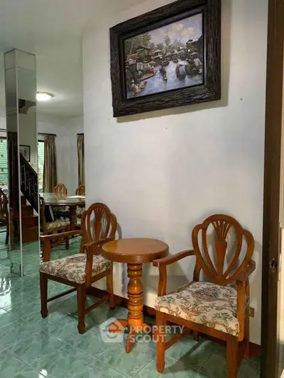 Charming interior with elegant wooden chairs and wall art, perfect for cozy living spaces.