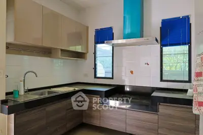 Modern kitchen with sleek cabinetry and large windows for natural light