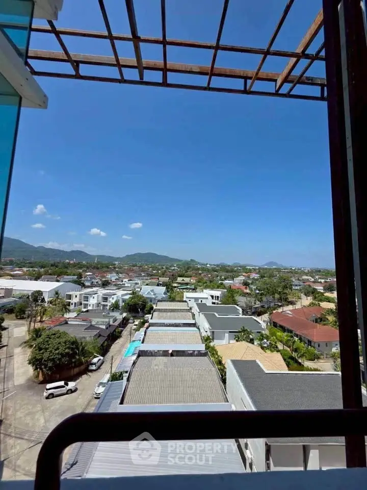 Stunning rooftop view of suburban neighborhood with clear blue skies and distant mountains.