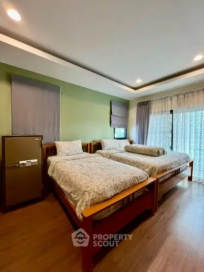 Spacious bedroom with twin beds and large windows in modern apartment