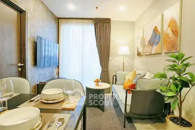 Modern living room with stylish decor and dining area, featuring a cozy sofa and wall art.