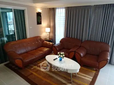Elegant living room with leather sofas and modern decor in a cozy apartment setting.