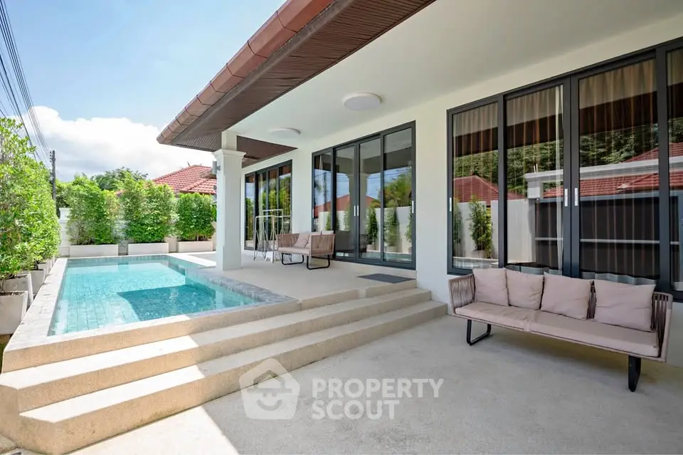 Luxurious modern home with private pool and stylish patio seating, perfect for relaxation.