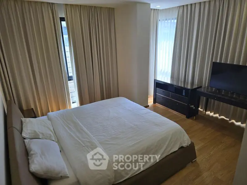 Modern bedroom with elegant curtains and sleek furniture, perfect for a cozy retreat.