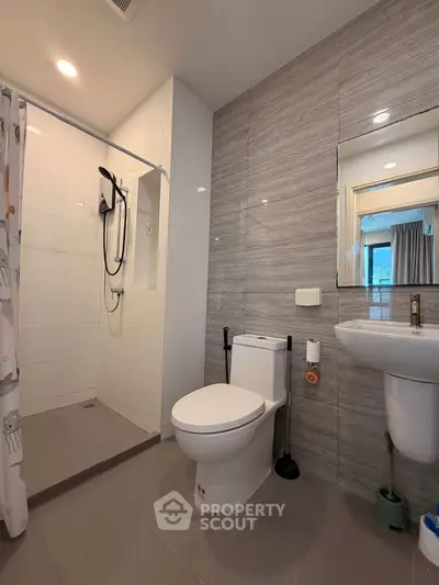 Modern bathroom with sleek shower and contemporary fixtures in a stylish apartment.