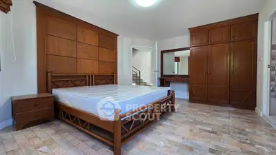 Spacious bedroom with wooden furniture and ample storage space