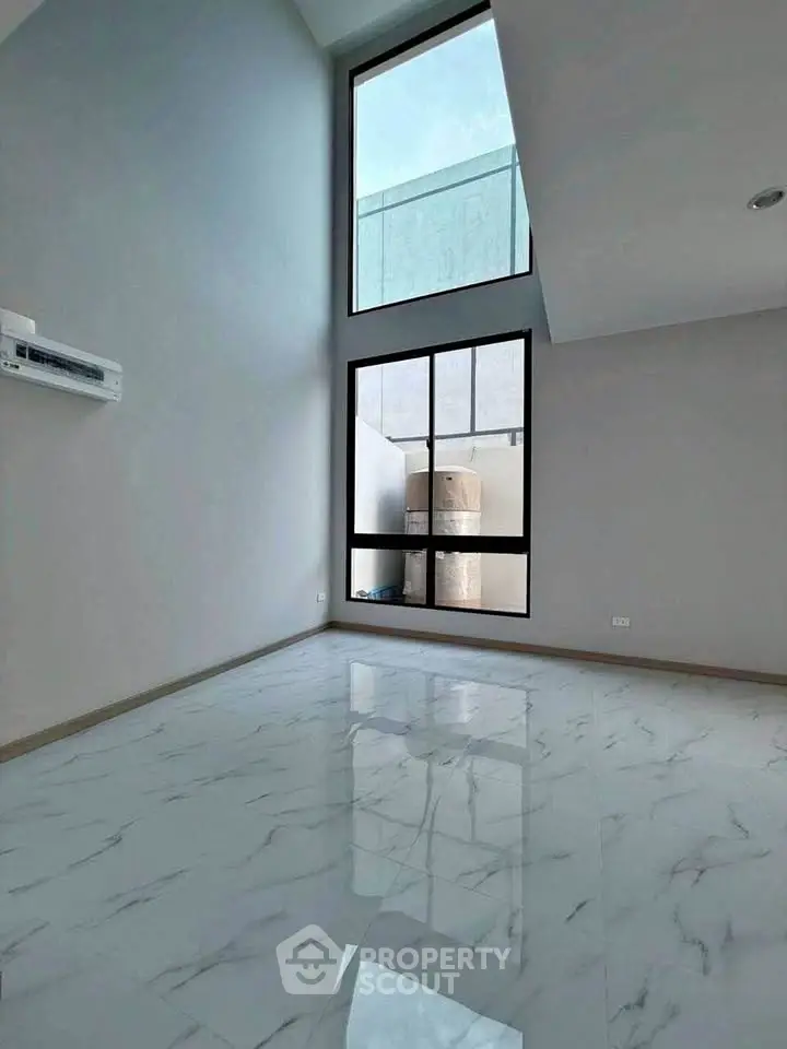 Spacious modern living room with high ceilings and large windows