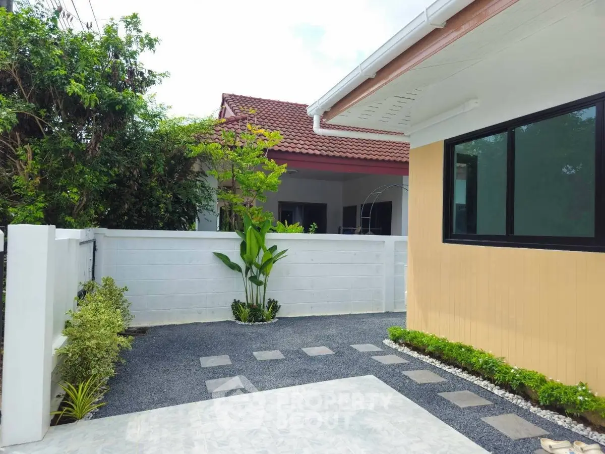 Charming exterior view of a modern home with a landscaped garden and paved walkway.