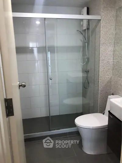 Modern bathroom with glass shower enclosure and sleek fixtures.