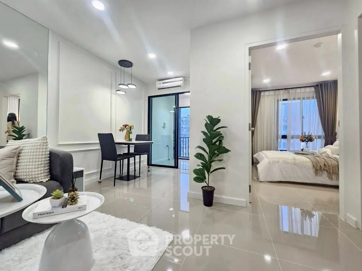 Modern open-plan living room with dining area and bedroom view