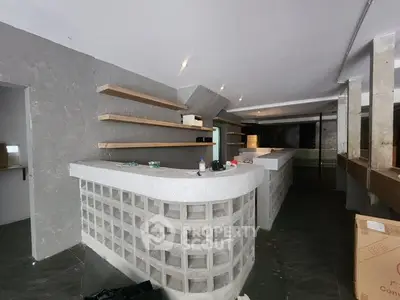 Spacious commercial interior with modern concrete bar and open shelving