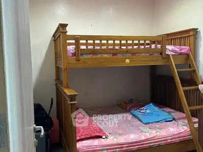 Cozy bedroom with wooden bunk bed and colorful bedding