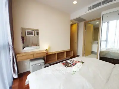 Modern bedroom with elegant decor and natural light, featuring a stylish vanity and cozy atmosphere.