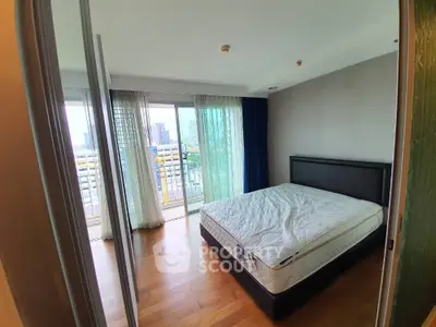 Spacious bedroom with balcony and city view in modern apartment