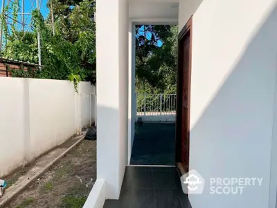 Modern exterior entrance with sleek design and lush greenery view