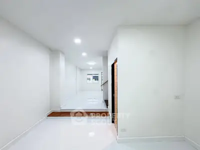 Spacious modern interior with sleek white flooring and walls, perfect for customization.