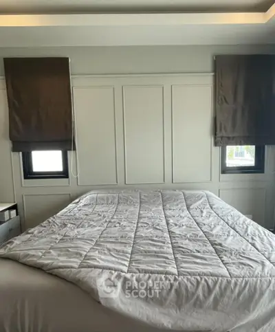 Elegant bedroom with a large comfortable bed, stylish paneling, and modern window treatments, perfect for a restful retreat in a contemporary home.